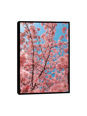 Quadro decorativo de uma árvore com flores rosa em destaque, contrastando com um céu azul sereno.