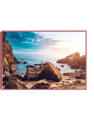 Quadro de Praia Deserta: Decoração Significativa e Inspiradora - imagem de uma praia deserta cercada por pedras, com mar calmo e céu nublado.