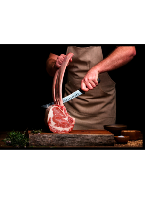 Quadro de costelas de cordeiro em fundo preto, destacando a polpa suculenta e o cozinheiro preparando a arte culinária.