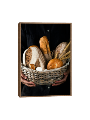 Quadro cesta de pães com pães variados, espigas de trigo e ovos brancos, perfeito para decoração de cozinha.